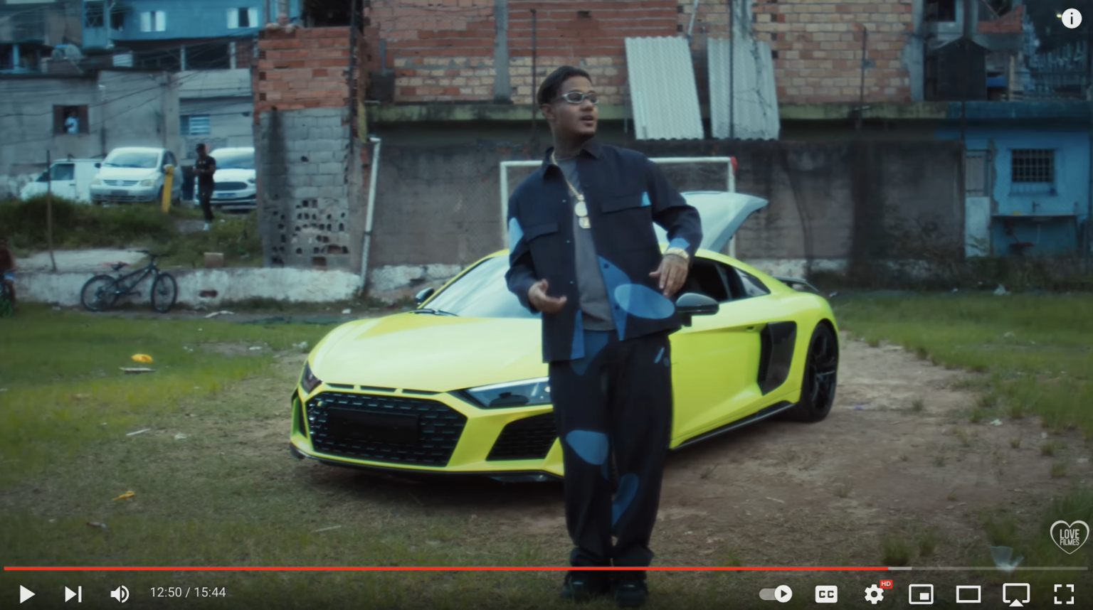 Carros luxuosos em frente a favela.